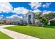 Charming two-story home featuring a manicured lawn and lush landscaping, showcasing curb appeal at 7263 Winding Lake Cir, Oviedo, FL 32765