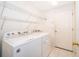Clean laundry room with a side-by-side washer and dryer and white wire rack shelving at 7263 Winding Lake Cir, Oviedo, FL 32765
