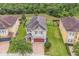 Aerial view of a home with a red door, large lawn, and manicured landscaping at 7521 Marker Ave, Kissimmee, FL 34747