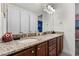 Bathroom featuring double sinks with granite counters and white cabinets for plenty of storage at 7521 Marker Ave, Kissimmee, FL 34747