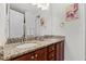 Well-lit bathroom with double sinks, granite countertops, and wood cabinets at 7521 Marker Ave, Kissimmee, FL 34747