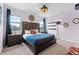 Relaxing bedroom featuring a king size bed, dark hardwood furniture, and two windows at 7521 Marker Ave, Kissimmee, FL 34747