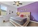 Charming bedroom featuring carpet floors, lavender walls, and neutral-toned bedding at 7521 Marker Ave, Kissimmee, FL 34747