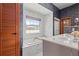 Bathroom with marble, large tub under window, and vanity with single sink at 8554 Amber Oak Dr, Orlando, FL 32817