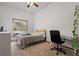 Bright bedroom featuring a ceiling fan, large window, and a small desk for study at 8554 Amber Oak Dr, Orlando, FL 32817