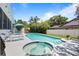 A backyard featuring a pristine pool with an attached jacuzzi and a spacious patio at 8554 Amber Oak Dr, Orlando, FL 32817