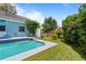 Backyard pool with a bright blue lining, and surrounding trees and grass at 8554 Amber Oak Dr, Orlando, FL 32817