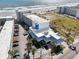 An aerial shot showcases the building's architecture, parking, and proximity to the sandy beach and ocean waves at 935 S Atlantic Ave # 302, Daytona Beach, FL 32118