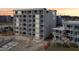 A multi-story condo building featuring private balconies, surrounded by sand, with sunset sky in the background at 935 S Atlantic Ave # 302, Daytona Beach, FL 32118