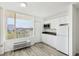 Bright kitchen featuring white cabinets, gray countertops, and updated appliances with a window view at 935 S Atlantic Ave # 302, Daytona Beach, FL 32118