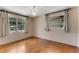 This light and airy bedroom features hardwood floors, neutral paint, and dual windows with bright sunlight at 944 Essex Rd, Daytona Beach, FL 32117