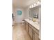 Well-lit bathroom features dual sinks, tile flooring, and a large mirror for added convenience and style at 103 Orchid Ct, Poinciana, FL 34759