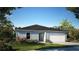 Charming single-story home features a two-car garage, manicured lawn, and lush landscaping at 103 Orchid Ct, Poinciana, FL 34759