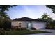 Charming single-story home features a two-car garage, manicured lawn, and lush landscaping at 103 Orchid Ct, Poinciana, FL 34759