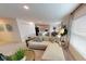 Bright and airy living room showcasing a modern sectional sofa and seamless flow to the kitchen and dining area at 103 Orchid Ct, Poinciana, FL 34759