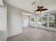 Enclosed sun room with tan carpet, windows, and a ceiling fan at 10350 Sw 62Nd Terrace Rd, Ocala, FL 34476