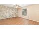 Bedroom featuring stone accent wall, wood-look flooring, and a ceiling fan at 109 Long Leaf Pine Cir, Sanford, FL 32773