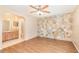 Bedroom featuring stone accent wall, wood-look flooring, and ensuite bath at 109 Long Leaf Pine Cir, Sanford, FL 32773