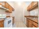 Kitchen featuring white appliances, wood cabinets, and tile flooring at 109 Long Leaf Pine Cir, Sanford, FL 32773