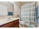 Bathroom includes vanity, toilet and a shower with a blue and white striped shower curtain at 11213 Grander Dr, Windermere, FL 34786