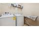 Bright laundry room with washer, dryer, and wire shelving for organized storage of supplies at 11213 Grander Dr, Windermere, FL 34786