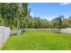 Expansive grassy backyard, enclosed by a white picket fence. Perfect for outdoor play at 11225 Cypress Trail Dr, Orlando, FL 32825