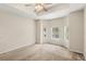 A spacious bedroom with a tray ceiling, a ceiling fan, and a bay window overlooking the pool at 11225 Cypress Trail Dr, Orlando, FL 32825