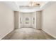 An empty bedroom with a tray ceiling, a ceiling fan, and a bay window overlooking the backyard pool at 11225 Cypress Trail Dr, Orlando, FL 32825