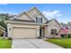 Attractive single-Gathering home showcasing a two-car garage, stone accents, and well-kept landscaping at 11225 Cypress Trail Dr, Orlando, FL 32825