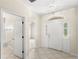 Welcoming home foyer with neutral tile, arched doorway, and transom window above the front door at 11225 Cypress Trail Dr, Orlando, FL 32825