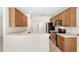 Charming kitchen boasts wooden cabinets, white countertops, and modern black appliances at 11225 Cypress Trail Dr, Orlando, FL 32825