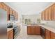 Sun-filled kitchen offers wooden cabinets, stainless steel appliances, and views of the backyard at 11225 Cypress Trail Dr, Orlando, FL 32825