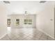 Spacious living room features a ceiling fan, tile floors, and views of the pool at 11225 Cypress Trail Dr, Orlando, FL 32825