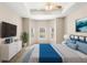 Primary bedroom with a tray ceiling, ceiling fan, and a bay window overlooking the backyard pool at 11225 Cypress Trail Dr, Orlando, FL 32825