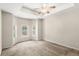 Bedroom featuring a tray ceiling, ceiling fan, and a bay window overlooking the backyard at 11225 Cypress Trail Dr, Orlando, FL 32825
