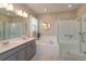 Bright bathroom features a double vanity, soaking tub, and glass enclosed shower at 1132 Sugarwood St, Davenport, FL 33837