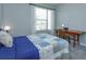 Cozy bedroom featuring a comfortable bed, natural light from the window, and a desk for work or study at 1132 Sugarwood St, Davenport, FL 33837