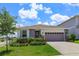 Beautiful single-story home featuring a two-car garage and well-manicured front yard with fresh landscaping at 1132 Sugarwood St, Davenport, FL 33837