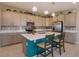 Well-lit kitchen with island seating, modern appliances, gray cabinetry, and pendant lighting at 1132 Sugarwood St, Davenport, FL 33837