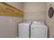 Functional laundry room with a washer, dryer, and shelving for storage, ensuring efficient laundry tasks at 1132 Sugarwood St, Davenport, FL 33837