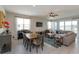Open-concept living room with a piano, dining table, and sliding glass doors to an outdoor deck at 1132 Sugarwood St, Davenport, FL 33837
