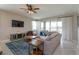Living room with large sectional sofa, ceiling fan, and sliding glass doors with natural light at 1132 Sugarwood St, Davenport, FL 33837
