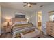 Comfortable bedroom with wood-look floors, natural light, and an ensuite bathroom entrance at 1132 Sugarwood St, Davenport, FL 33837