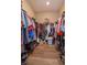 Spacious walk-in closet with extensive hanging racks, shoe storage, and wood-look flooring at 1132 Sugarwood St, Davenport, FL 33837