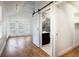 Bedroom featuring vaulted ceilings, wood-look flooring, and a sliding barn door to the bathroom at 1308 S Pennsylvania Ave # 3, Winter Park, FL 32789
