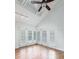Bedroom with wood floors, vaulted ceiling, track lighting, and plantation shuttered french doors at 1308 S Pennsylvania Ave # 3, Winter Park, FL 32789