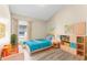 Bright bedroom with neutral walls, wood-look floors, a large window, and a playful collection of toys and books at 13146 Odyssey Lake Way, Orlando, FL 32826