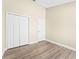 Bedroom featuring wood floors, closet, and a bright window overlooking the neighborhood at 13146 Odyssey Lake Way, Orlando, FL 32826