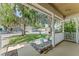 View from the covered front porch with trees draped in moss at 13146 Odyssey Lake Way, Orlando, FL 32826