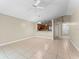 Open-concept living room with tile flooring connected to the kitchen and entryway at 13146 Odyssey Lake Way, Orlando, FL 32826